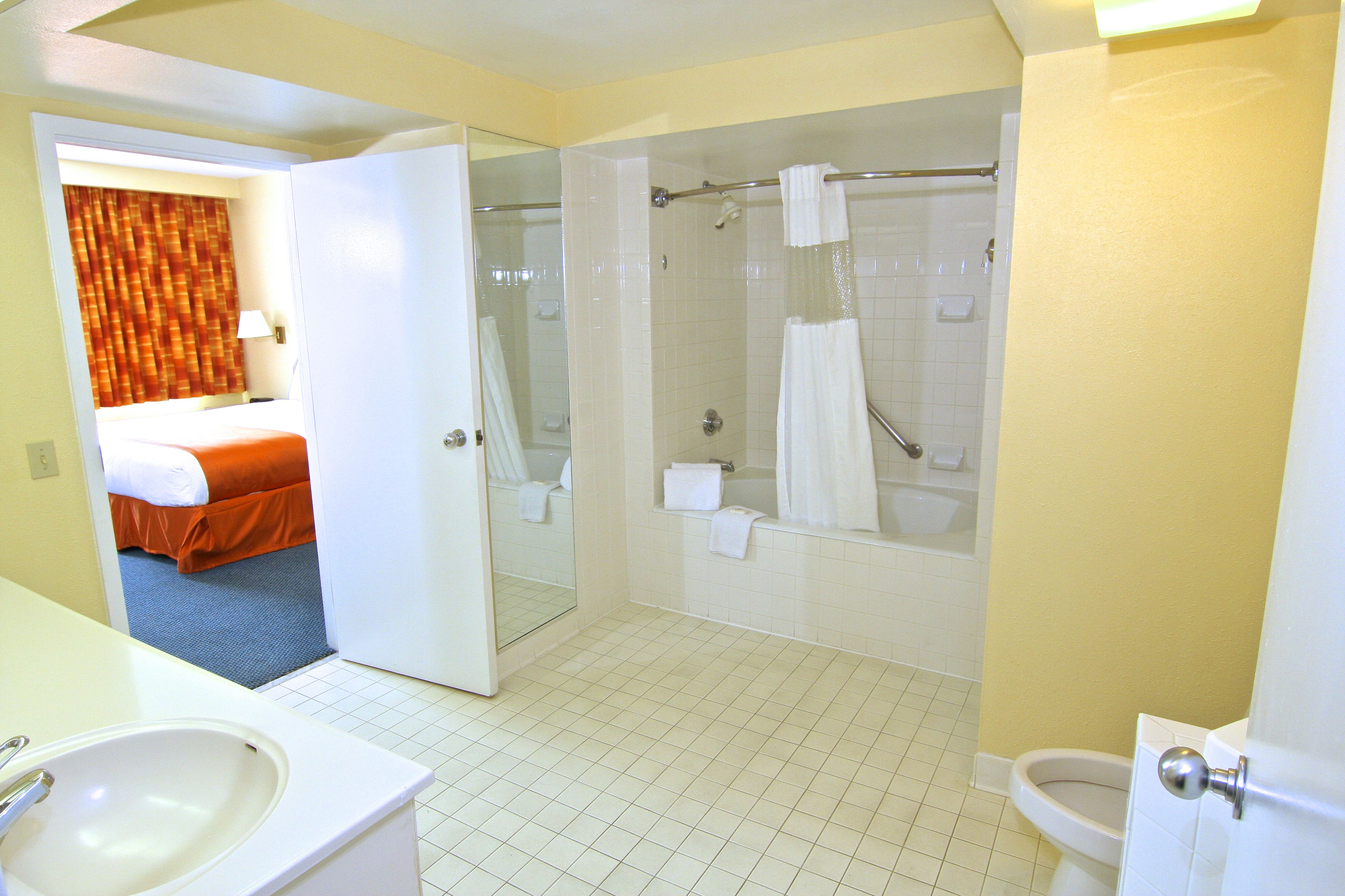 A hotel bathroom with a shower, toilet, and sink.