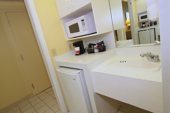 A spacious indoor area with a large checkered floor, a chessboard, and seating areas with red cushions. at Ramada by Wyndham Kissimmee Gateway