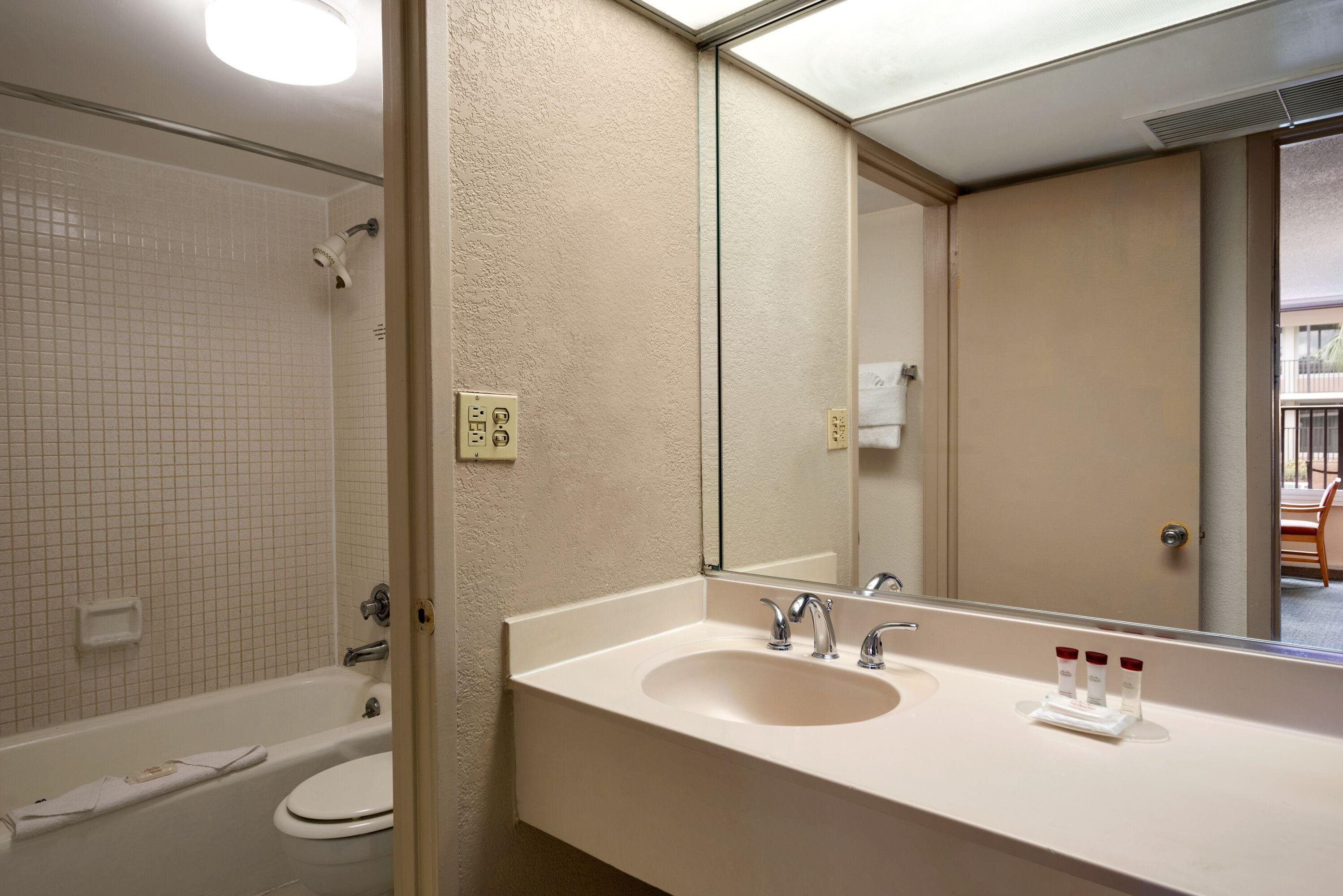 Un bany amb banyera, un lavabo i un mirall.