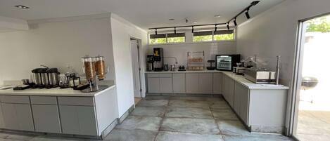 A modern kitchen with a central island, built-in appliances, and a large window providing natural light.