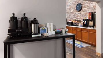 A coffee station with Bunn coffee makers, a Days Inn sign, and a clock on the wall.