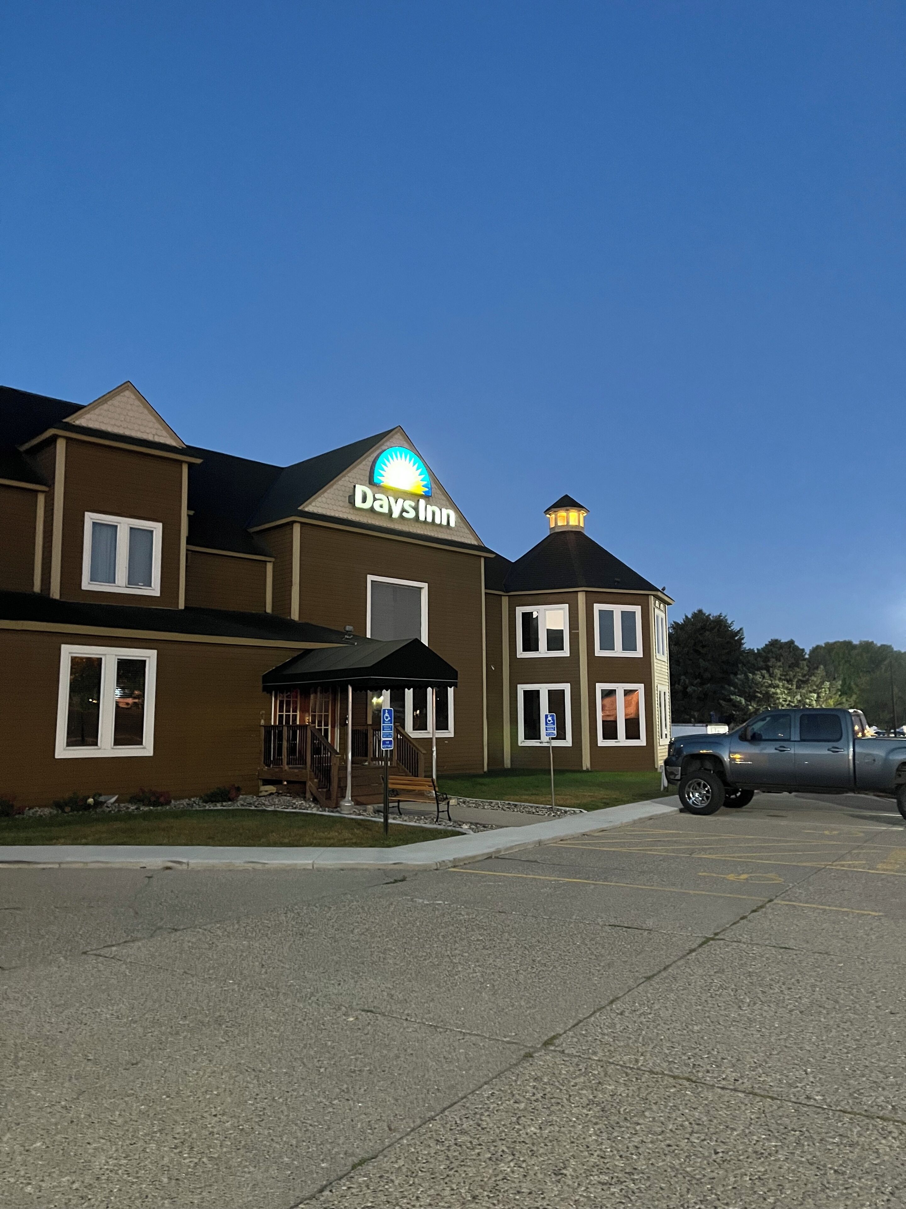 A Days Inn building with a parking lot and a covered outdoor seating area.