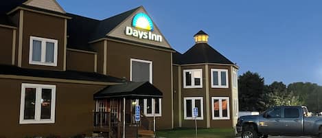 A Days Inn building with a parking lot and a covered outdoor seating area.