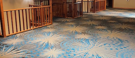Ein Hotelzimmer mit Holzvertäfelung, einem gemusterten Teppich und einem Oberlicht.