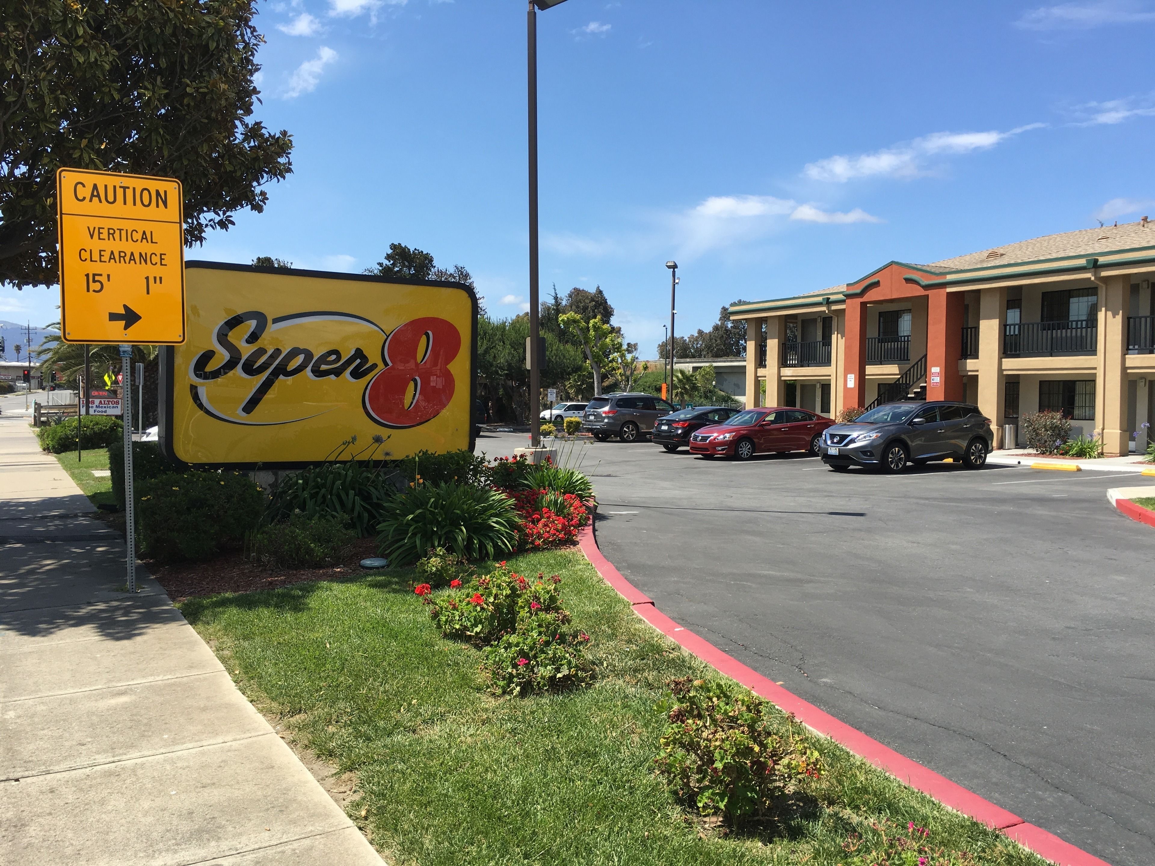 A Super 8 motel sign with a caution for vertical clearance of 15' 1".