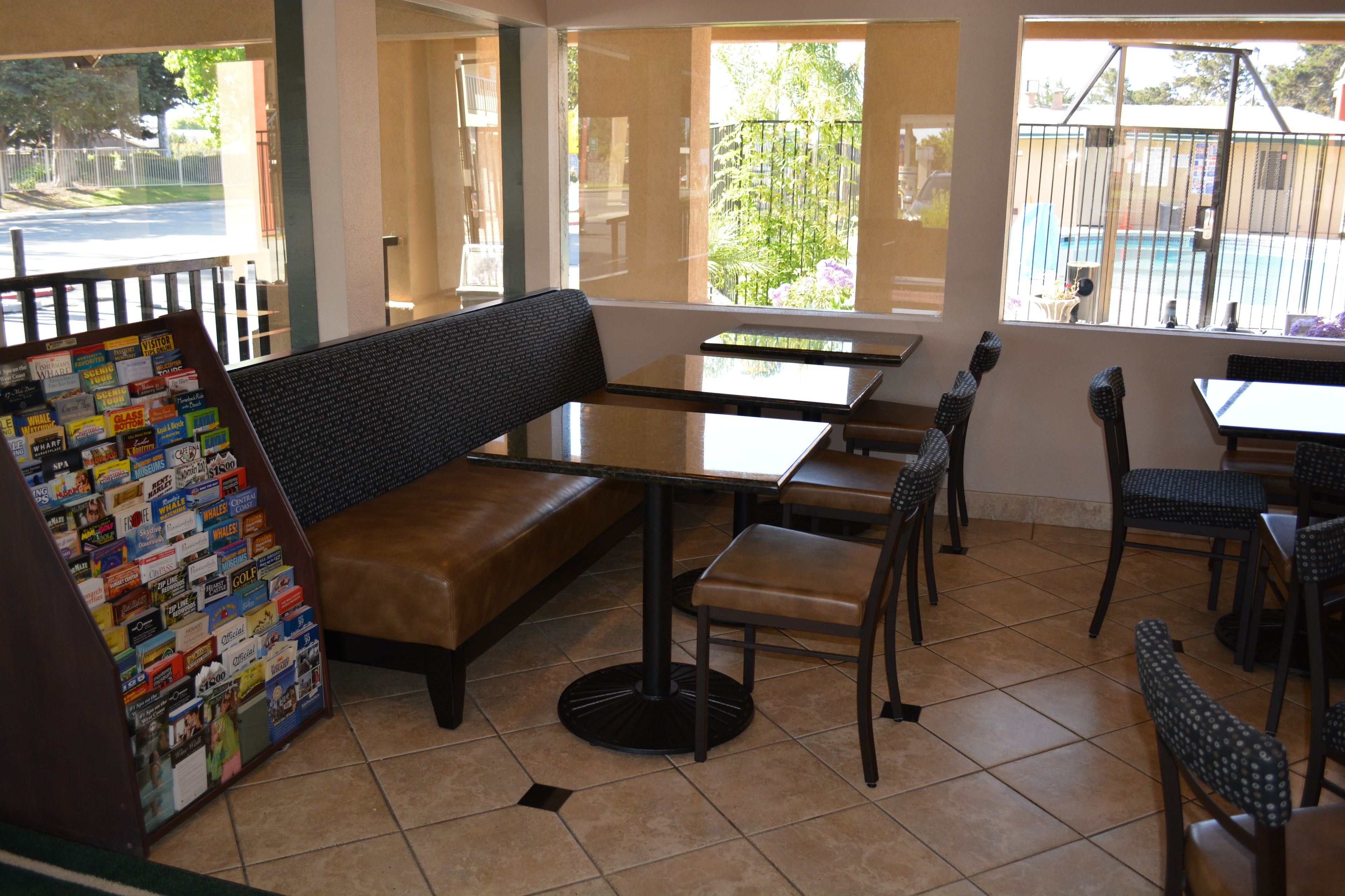 Un restaurante con zona de cabinas, mesas individuales y sillas.
