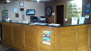 A reception desk with a clock, a television, and various informational posters. - Americas Best Value Inn York (York)