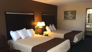A hotel room with two beds, a nightstand, a lamp, a painting, and a chair. - Americas Best Value Inn York (York)