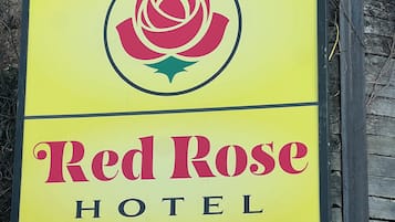A hotel sign with a red rose logo and the name 'Red Rose Hotel'.