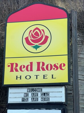 A hotel sign with a red rose logo and the name 'Red Rose Hotel'. - Red Rose Hotel (Covington)