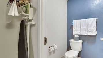 A bathroom with a toilet, towel rack, and paper towel dispenser.
