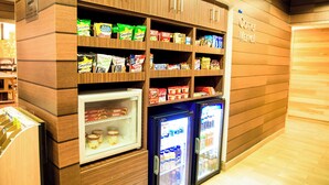 Un bar con scaffali pieni di merendine e bevande confezionate, e due vetrine refrigerate.