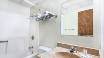 Een bad/douchecombinatie, een haardroger, handdoeken, zeep