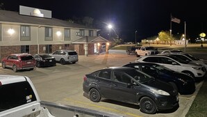 Un estacionamiento con varios autos estacionados frente a un edificio con un letrero de Days Inn.