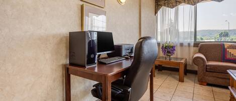 Une pièce comprenant un bureau, un ordinateur, une chaise et un canapé.