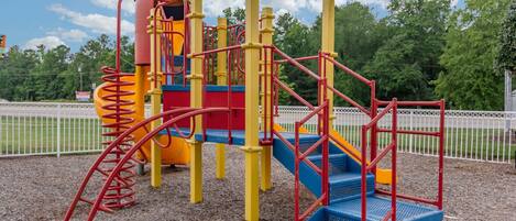 A playground with a slide, climbing structures, and a covered play area.