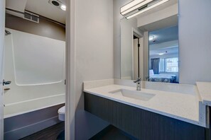 Ein Badezimmer mit Badewanne, Waschbecken und Spiegel.