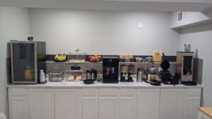A kitchenette with a refrigerator, coffee maker, waffle maker, and various food items on the counter. - Studio 6 Rock Springs WY Flaming Gorge (Rock Springs)