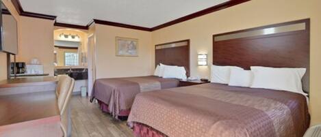 A hotel room with two beds, a desk, and a chair.