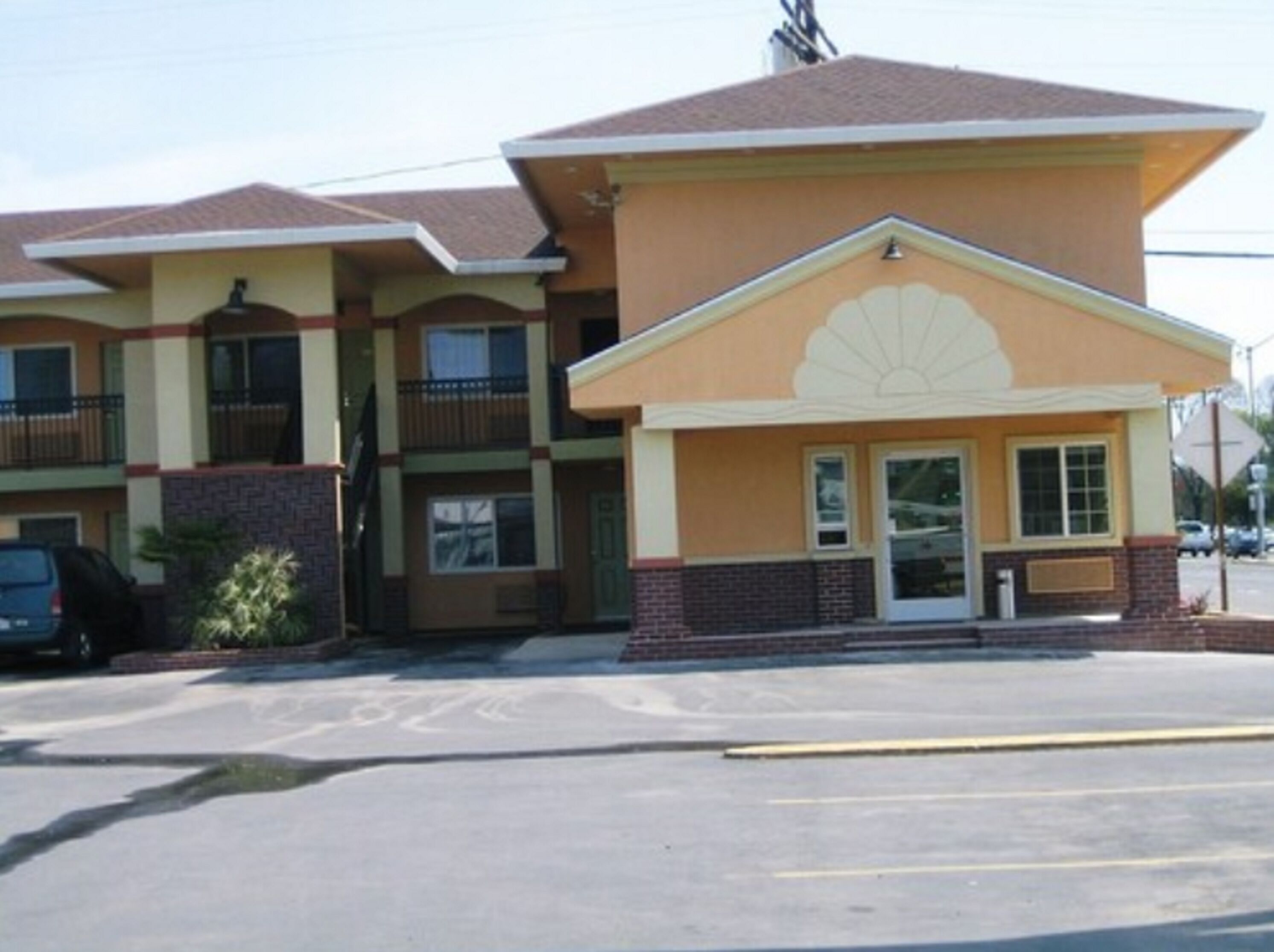 Ein zweistöckiges Motel mit gelber Fassade und braunem Dach.