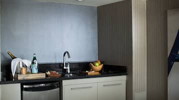 Una cocina moderna con lavavajillas integrado, un lavamanos y una tabla de madera con alimentos.