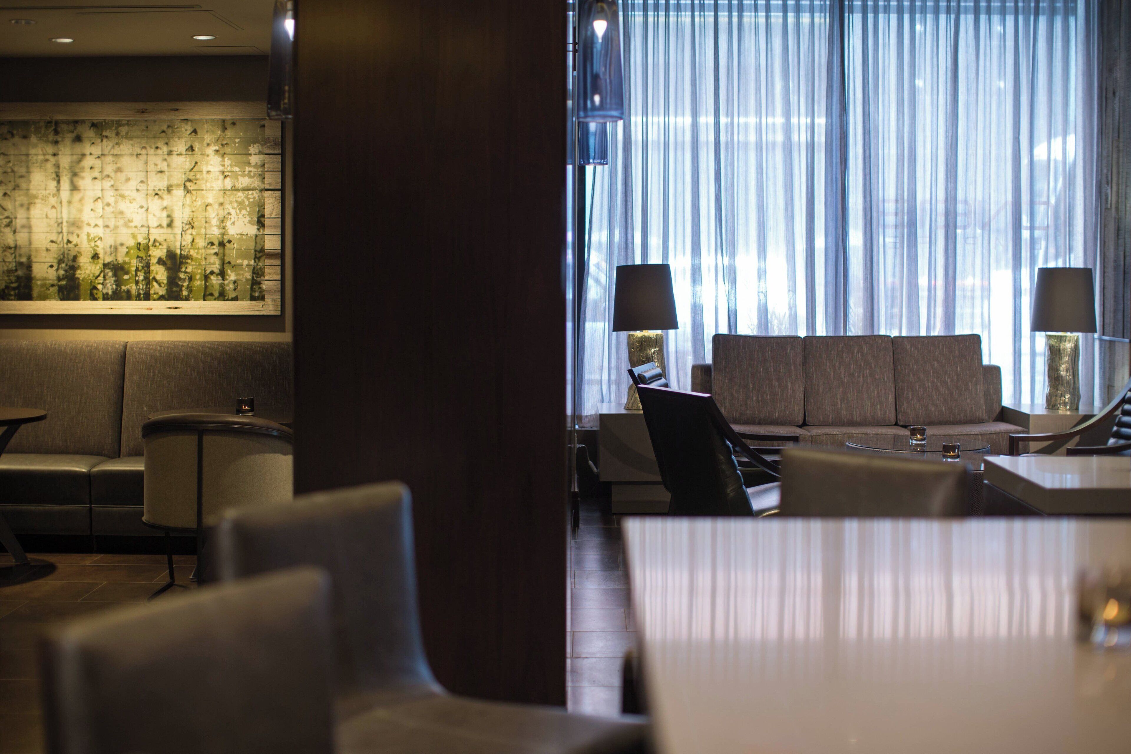 A modern hotel lobby with a sofa, chairs, and a table.