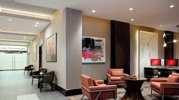 Eine moderne Hotelhalle mit Sitzbereichen, Kunstwerken und einer Rezeption.