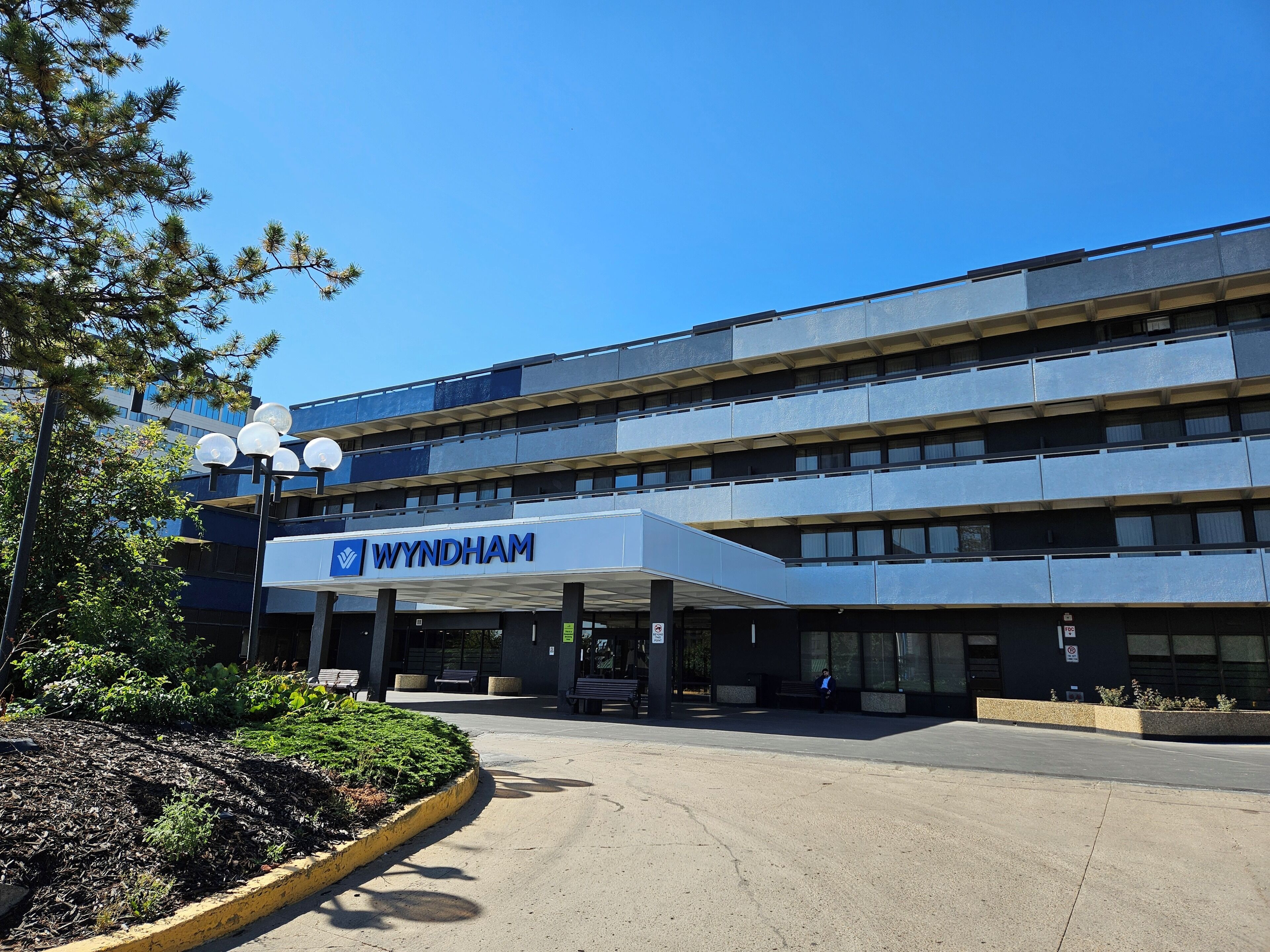 Un edificio moderno con un letrero que dice "WYNDHAM" y un área de entrada cubierta.
