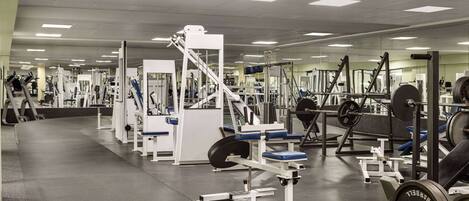 A gym with various exercise equipment, mirrors, and a clean, organized layout.