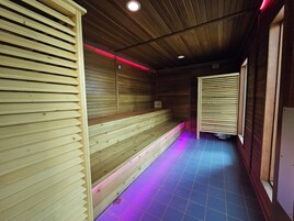 Una sauna con bancos de madera y suelo de baldosas.