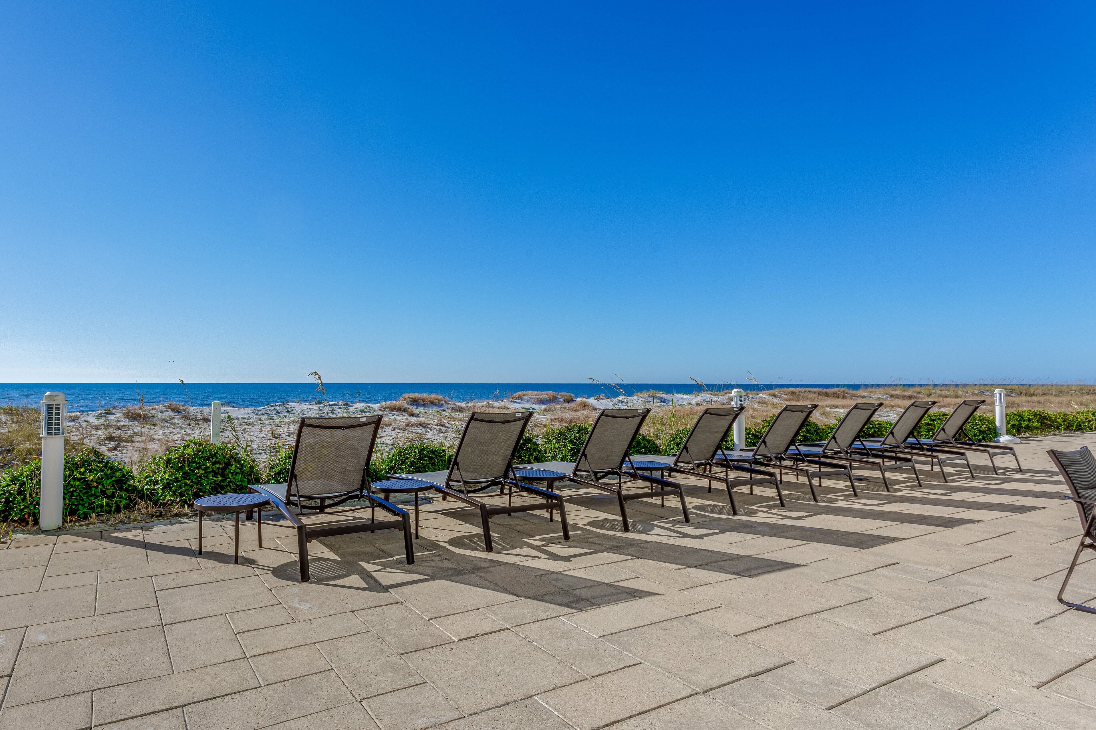 A row of sun loungers facing the beach with a clear view of the ocean.