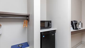 Una kitchenette equipada con microondas, cafetera y lavavajillas.