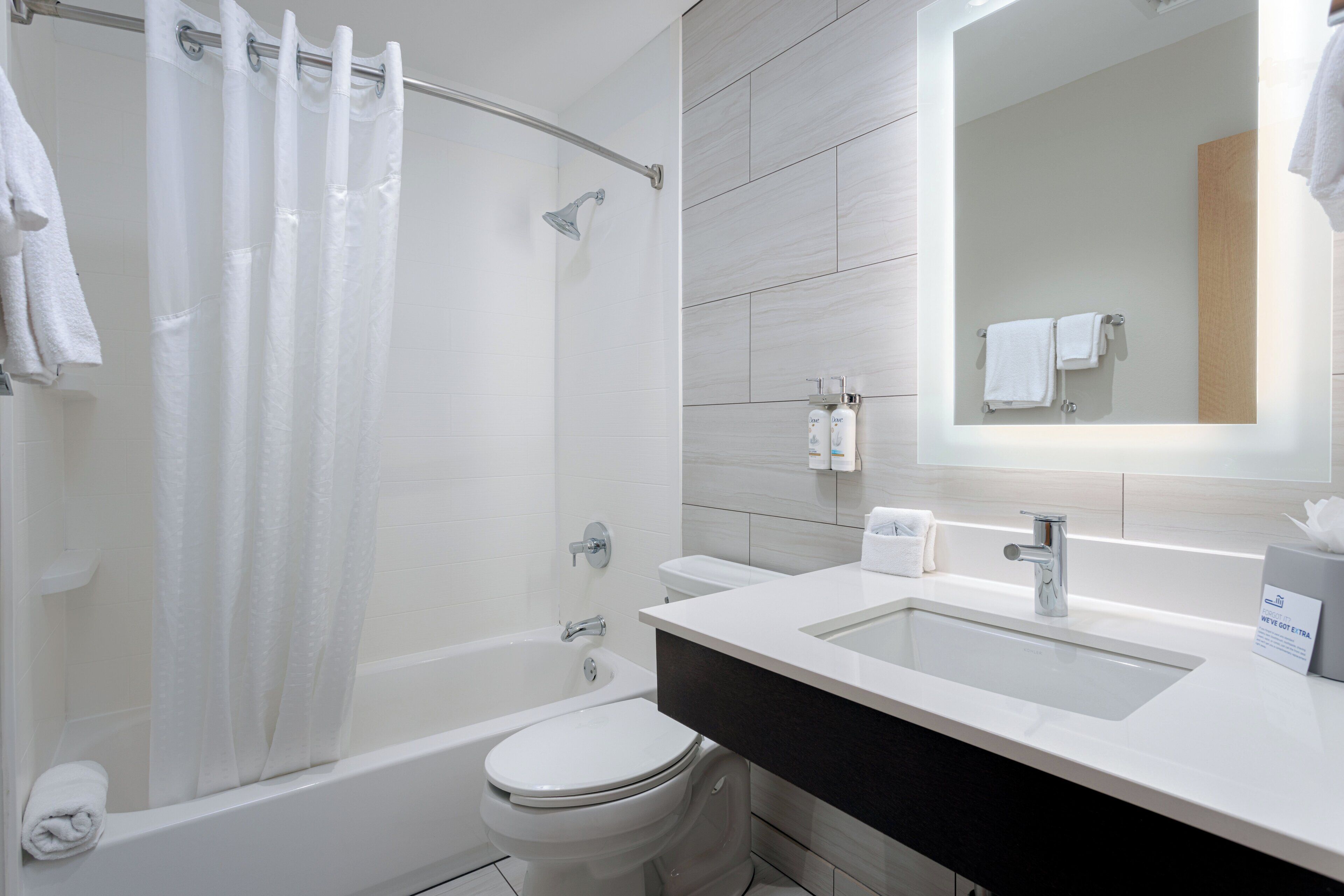 A modern bathroom with a bathtub, toilet, and sink.