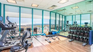 Un gimnasio con cintas de correr, pelotas de ejercicio y mancuernas.