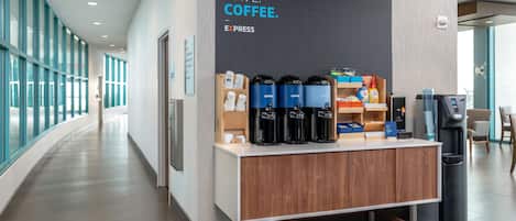 A coffee station with a sign that reads "MUST. HAVE. COFFEE." and a coffee machine.
