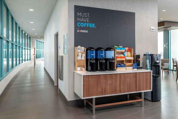 A coffee station with a sign that reads "MUST. HAVE. COFFEE." and a coffee machine.