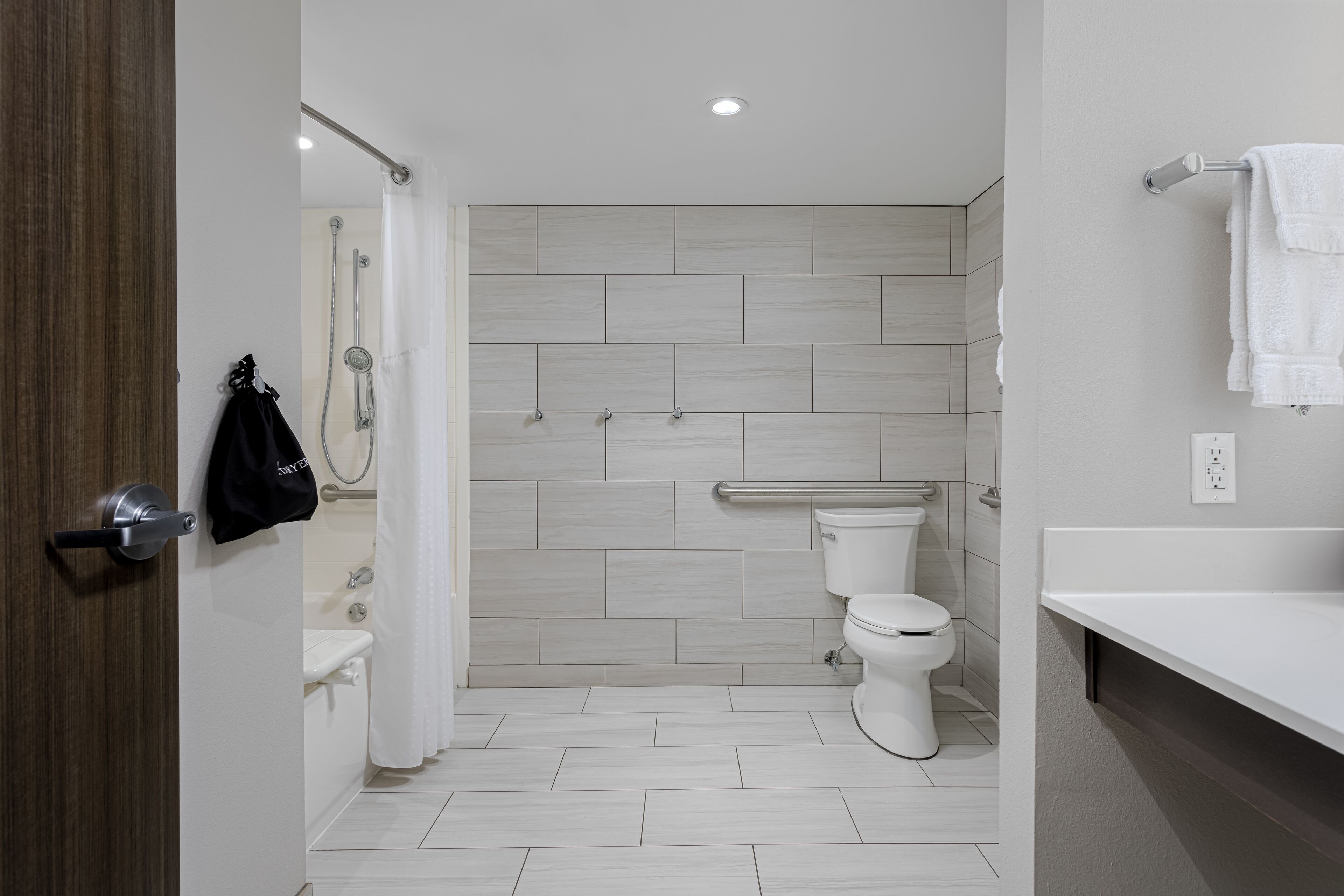A modern bathroom with a shower, toilet, and sink.