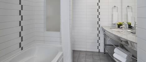 A modern bathroom with a bathtub, a shower, and a vanity with a sink and mirror.
