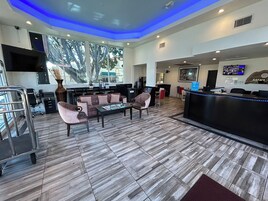 Un moderno vestíbulo de hotel con mostrador de recepción, zona de estar y amplios ventanales que ofrecen vistas al exterior.