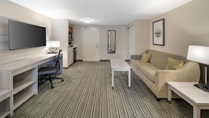 A hotel room with a flat-screen TV, a desk, a sofa, and a coffee table. - Best Western Plus Twin View Inn & Suites (Redding)
