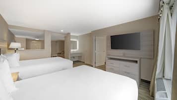 Une chambre d’hôtel avec deux lits, une télévision, un bureau et une salle de bain.