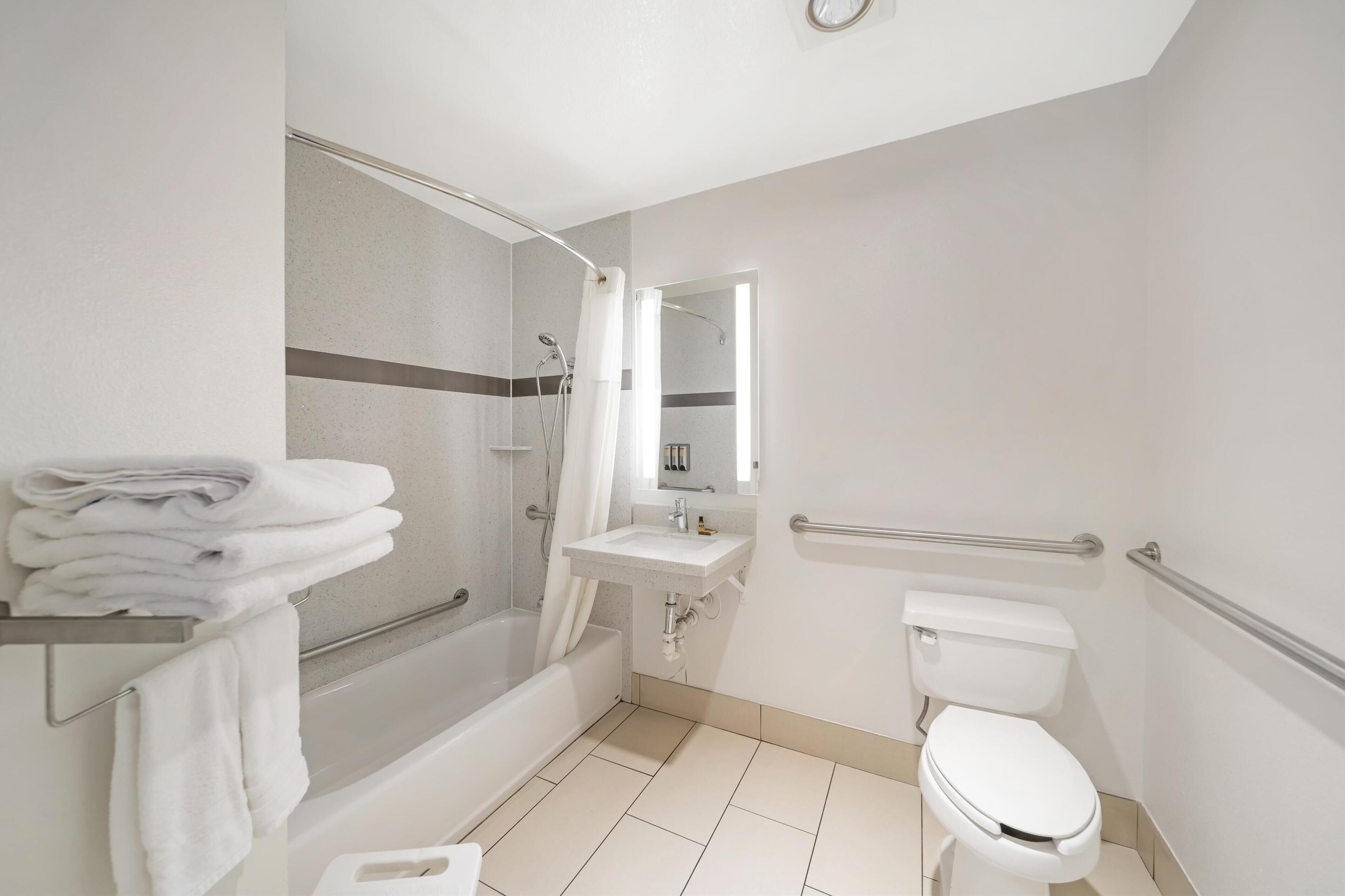 A modern bathroom with a bathtub, toilet, and sink.
