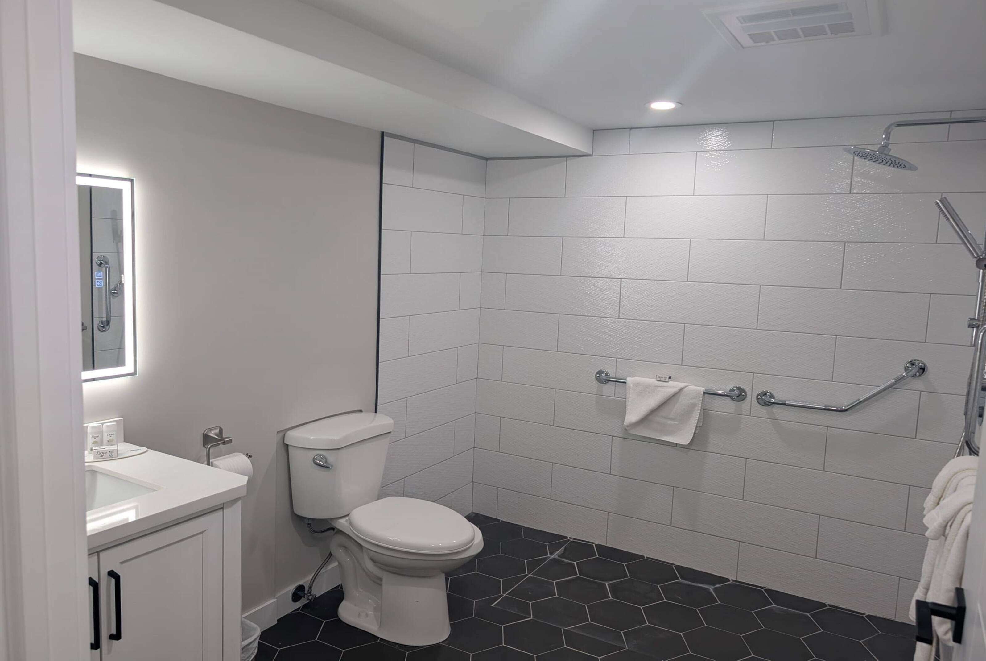 A modern bathroom with a white toilet, a sink, and a shower.