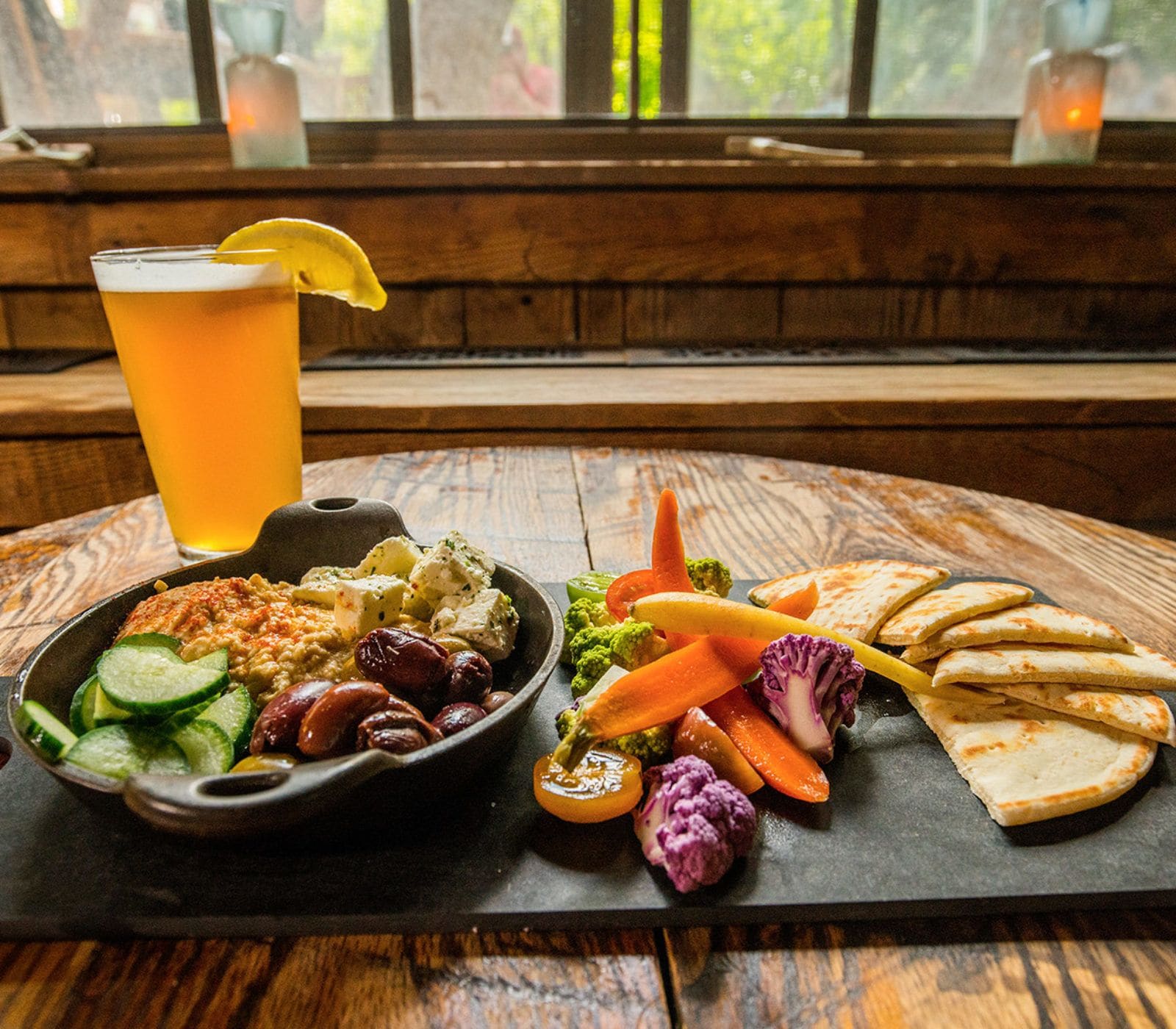 A meal with vegetables, a drink, and flatbread on a wooden table.