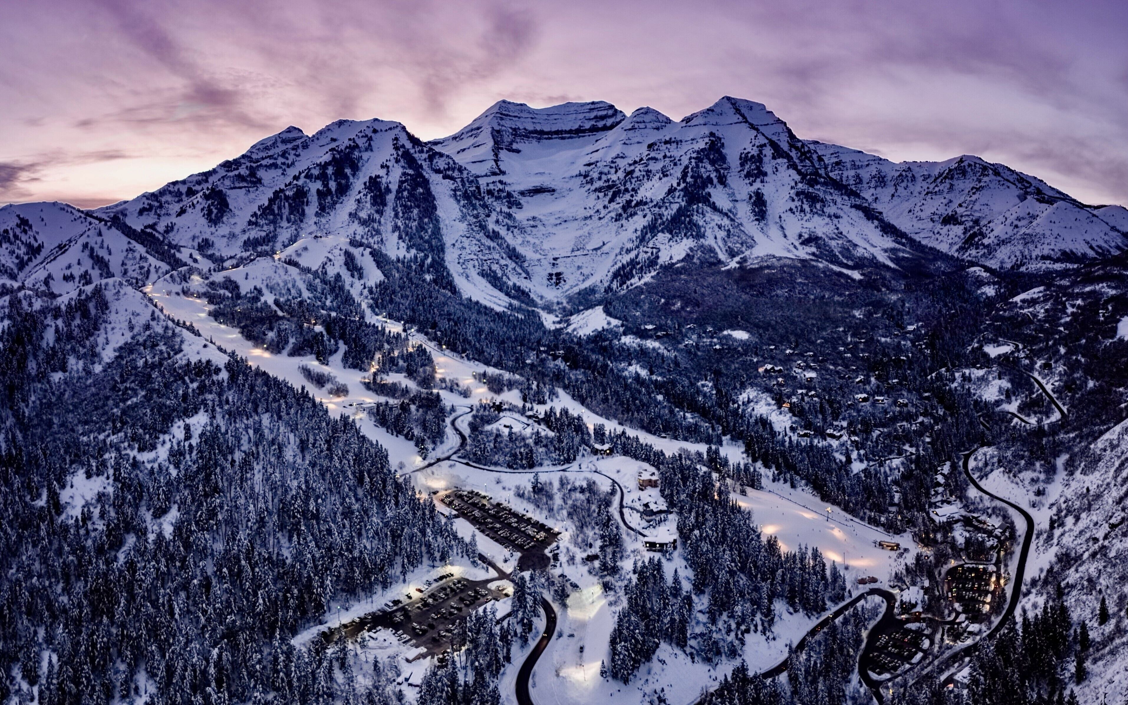 Un paisaje montañoso cubierto de nieve con carreteras sinuosas y edificios.
