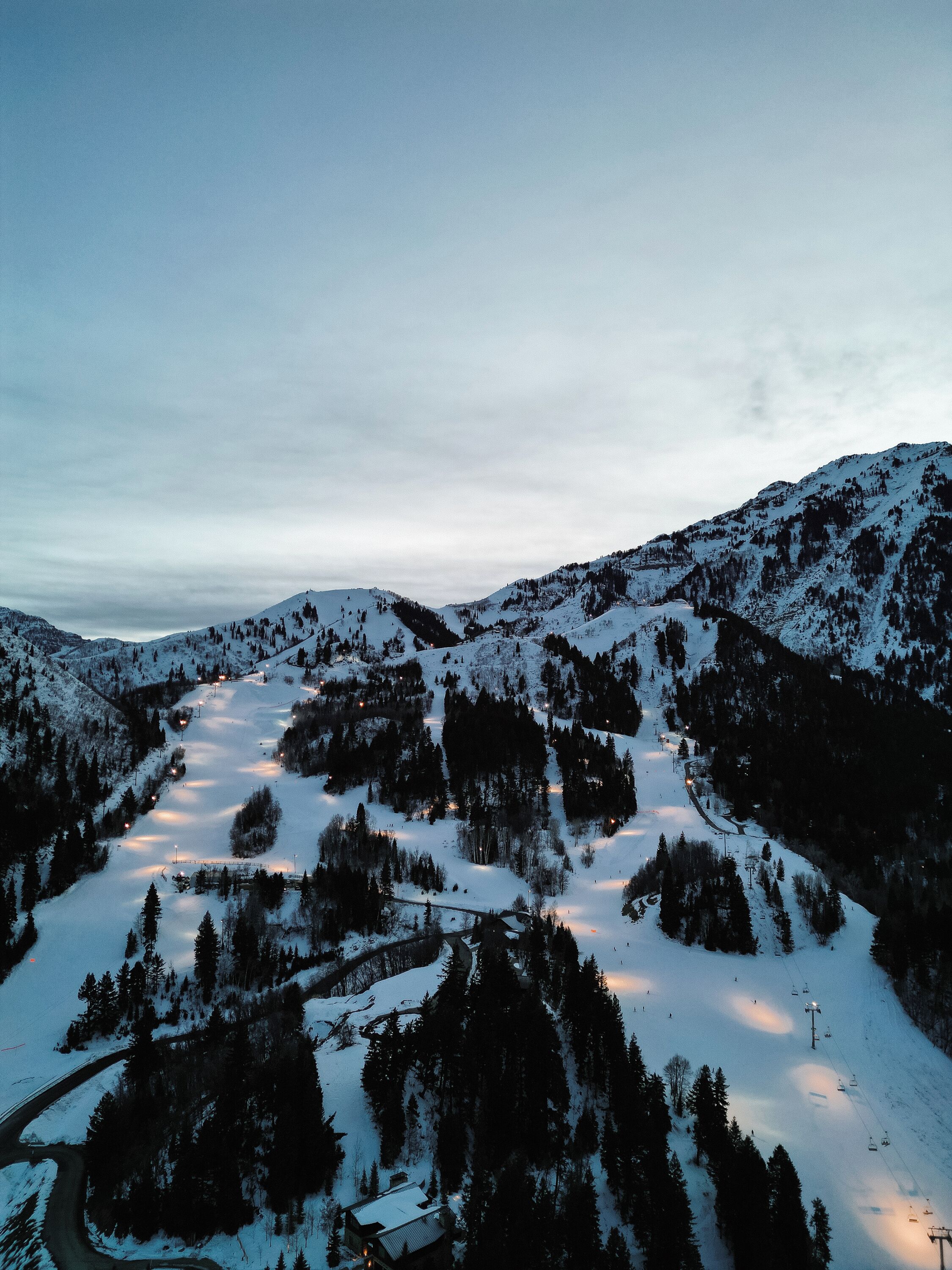 Schneebedeckte Berglandschaft mit Seilbahnen und einem kleinen Gebäude.
