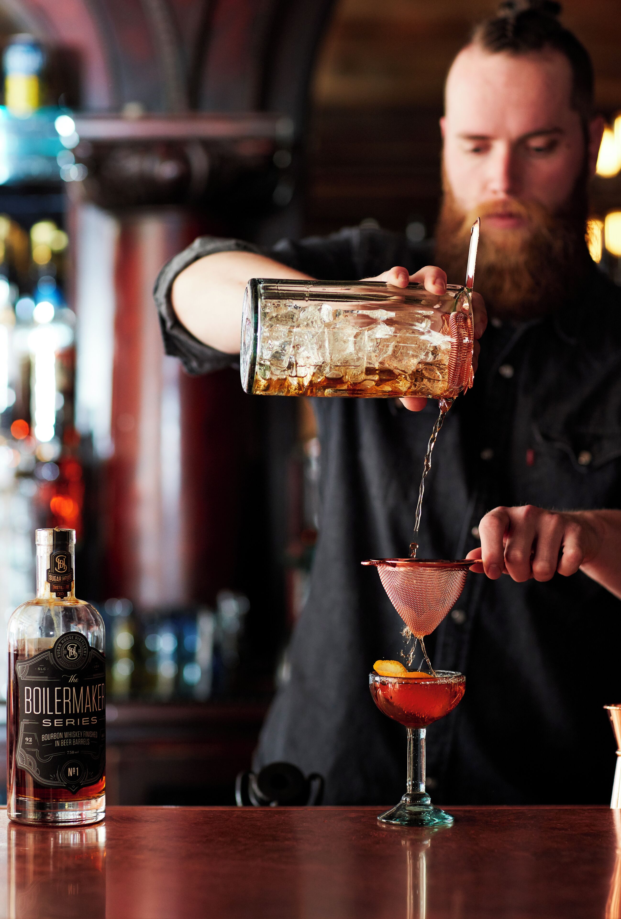 Un barman sirviendo una bebida en una copa de martini.