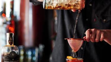 Un barman sirviendo una bebida en una copa de martini.