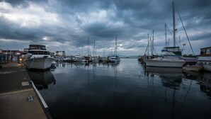 Un port de plaisance où des bateaux sont amarrés sous un ciel nuageux.
