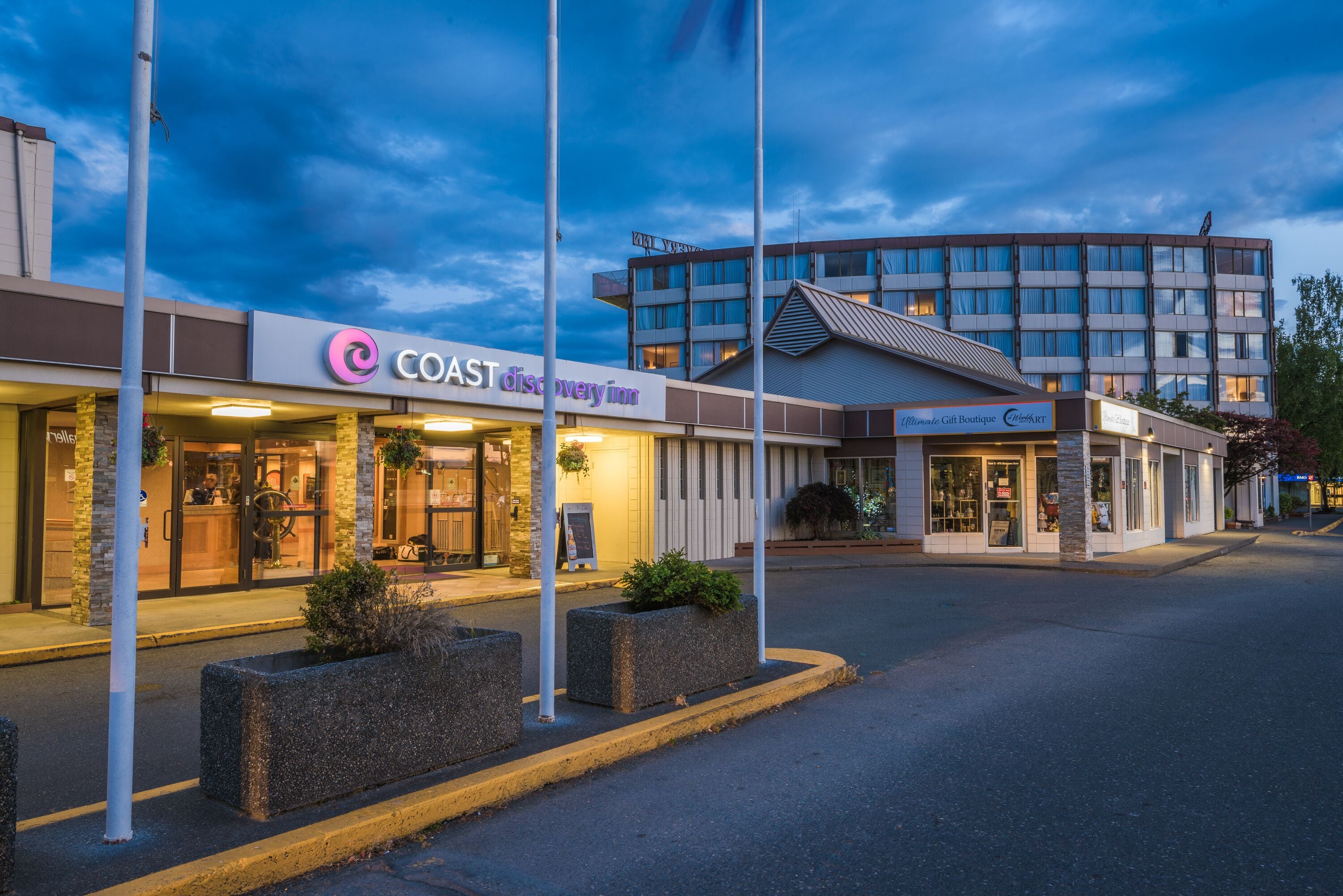 A hotel with a modern design, featuring a prominent sign for the 'Coast Discovery Inn'.
